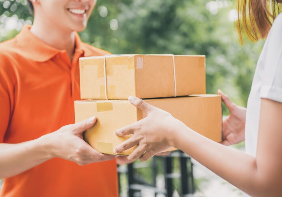 Delivery person handing over two packages.